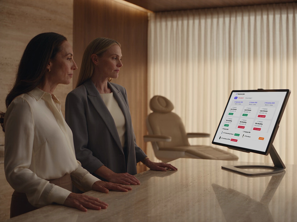 Two clinic colleagues review a DappleOS treatment and skincare plan together.