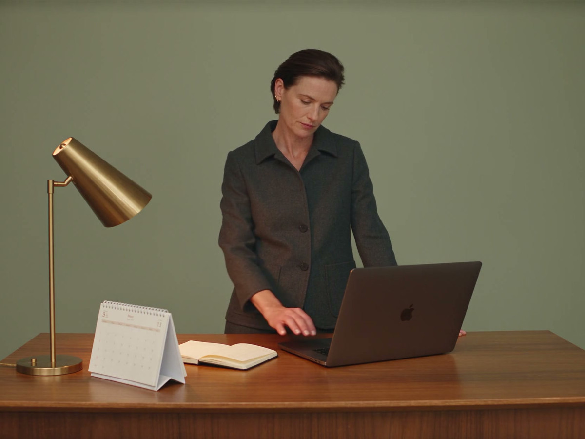 A clinic manager checks a calendar before selecting a period on their laptop
