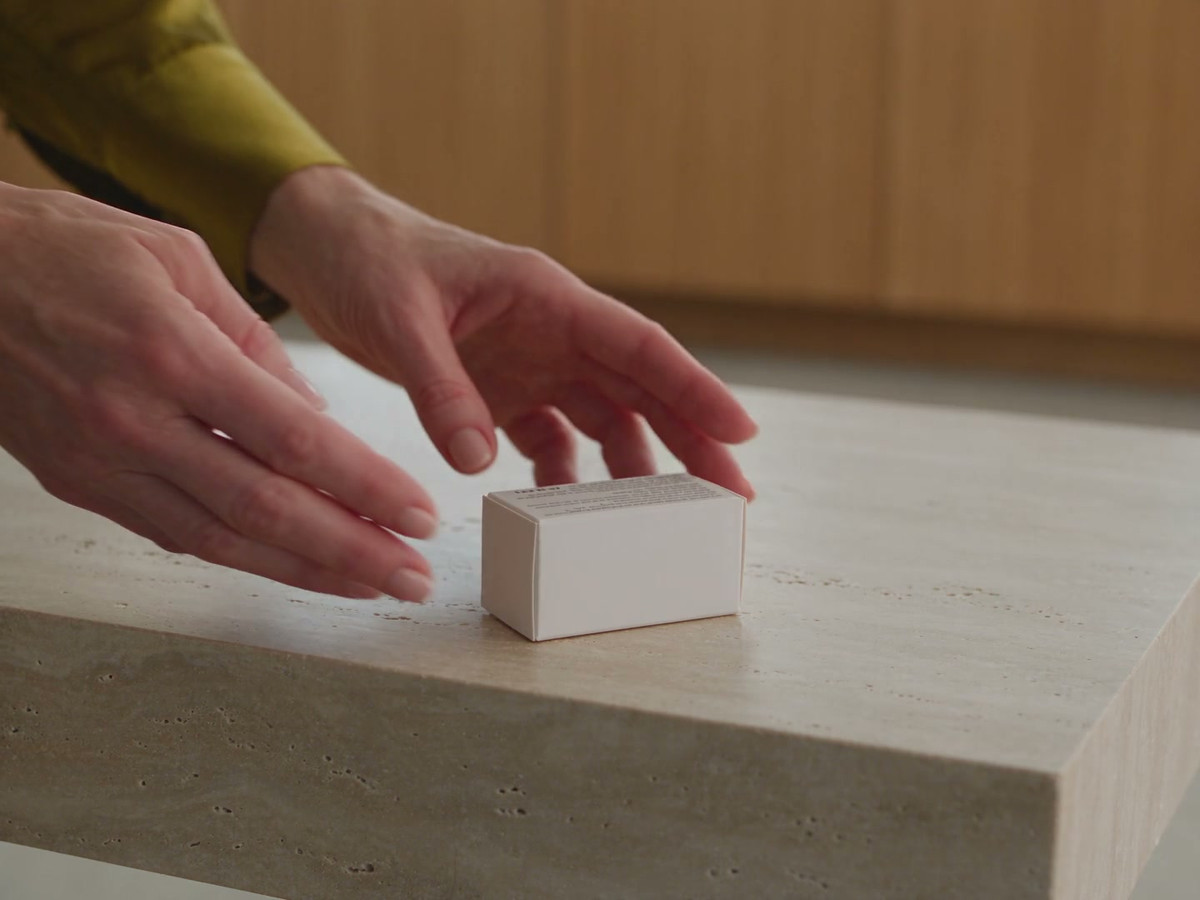 Hands check an unopened product package on a clinic work surface