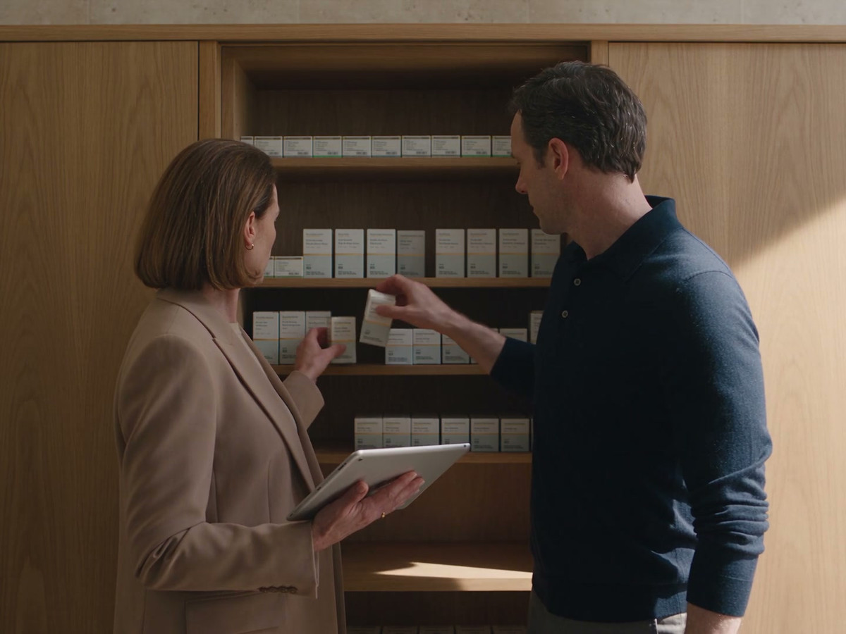 Two team members compare items on the stock shelf with their tablet