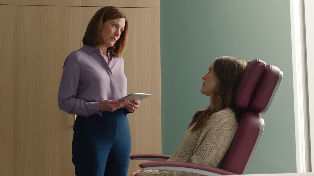 A practitioner listens to a client in a private cosmetic clinic.