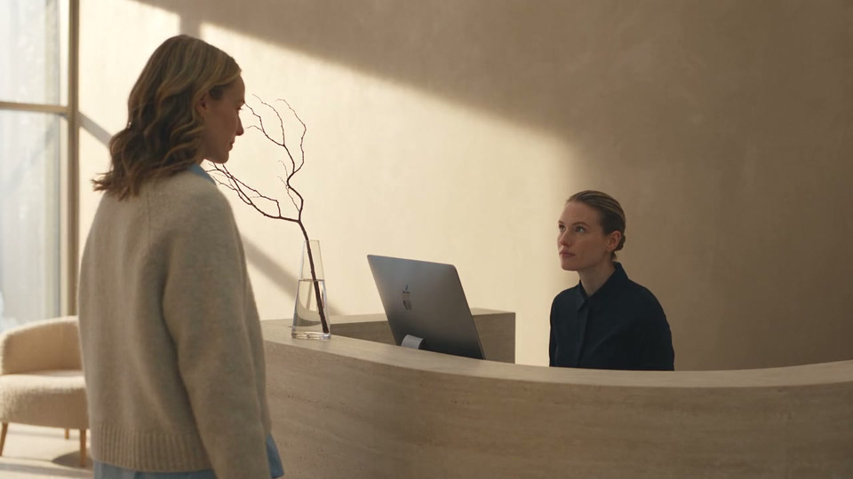 Illustrative footage of a receptionist reviewing work at the clinic desk