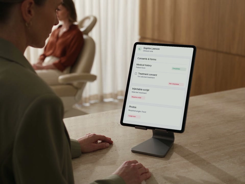 A practitioner reviews a patient record on an iPad before a consultation.