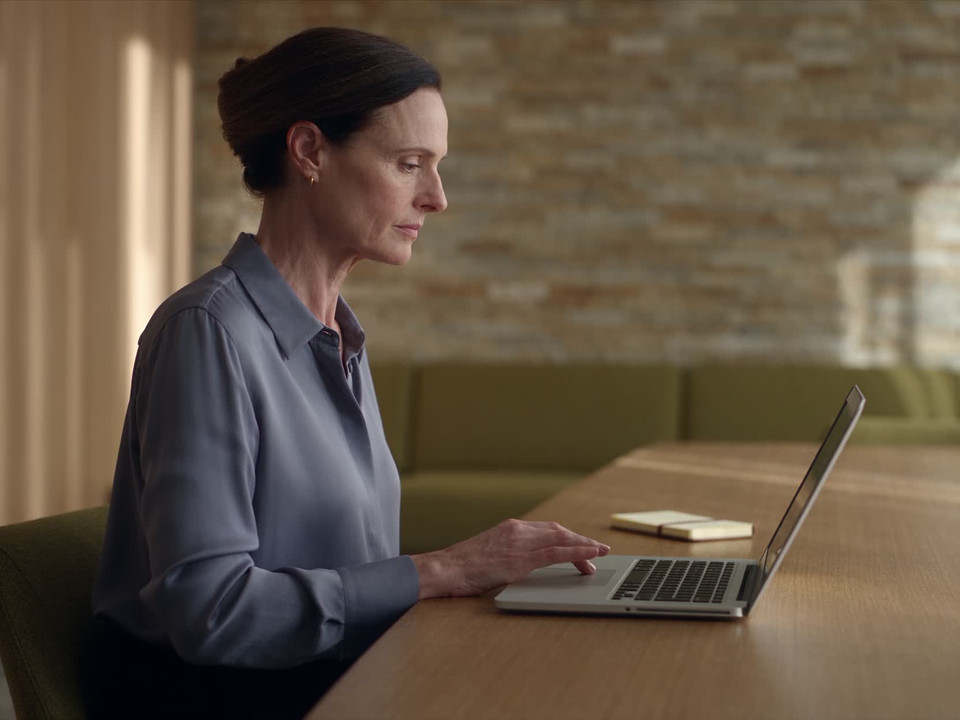 A clinic practitioner reviews information at a computer in a quiet workspace