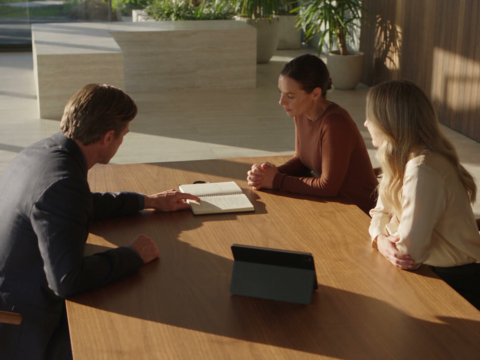 Three clinic colleagues discuss their next steps around a table