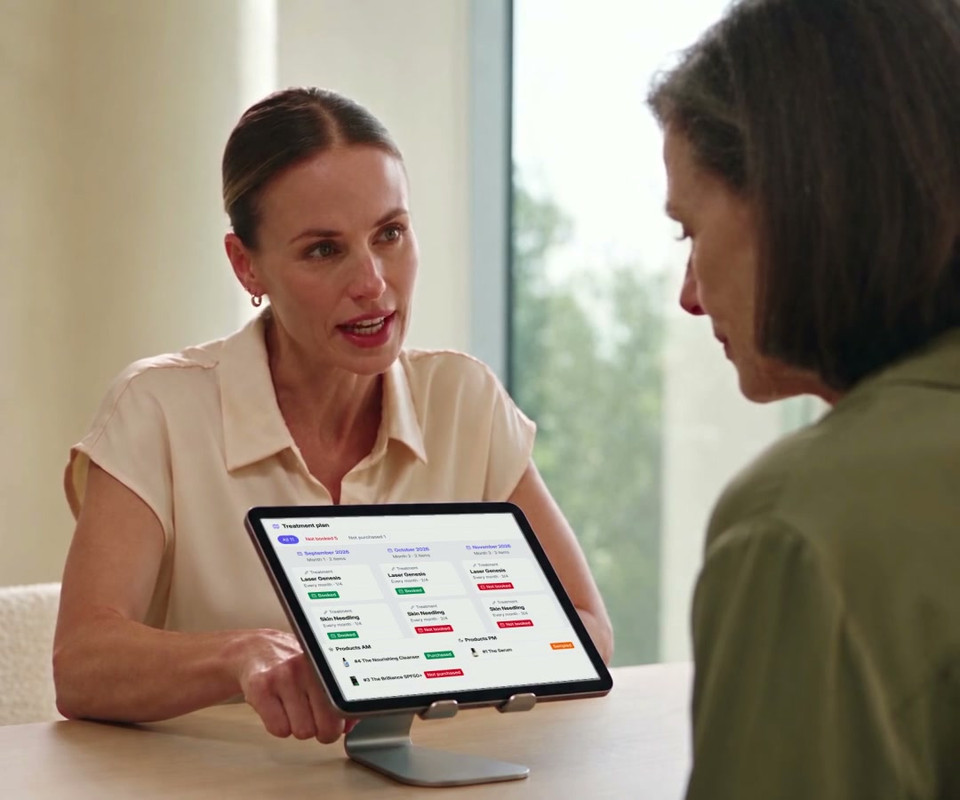 Illustrative consultation and skincare sample handoff, with a recreated treatment plan on the iPad and the clinic-branded patient app on the patient's phone.