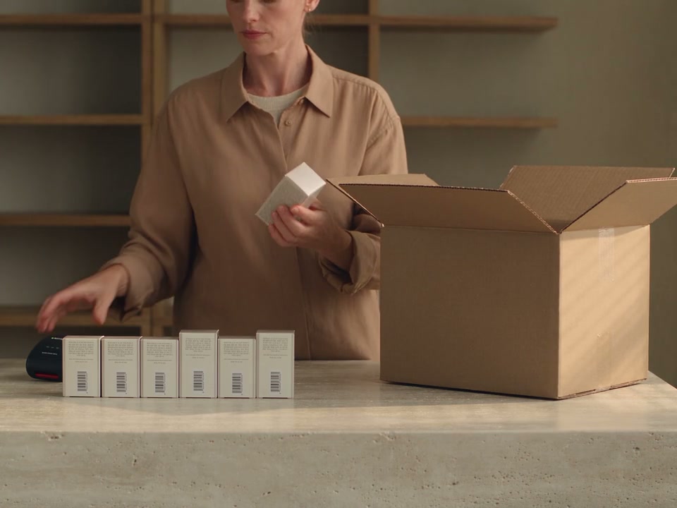 A team member checks unopened stock as a delivery is unpacked at a clinic bench